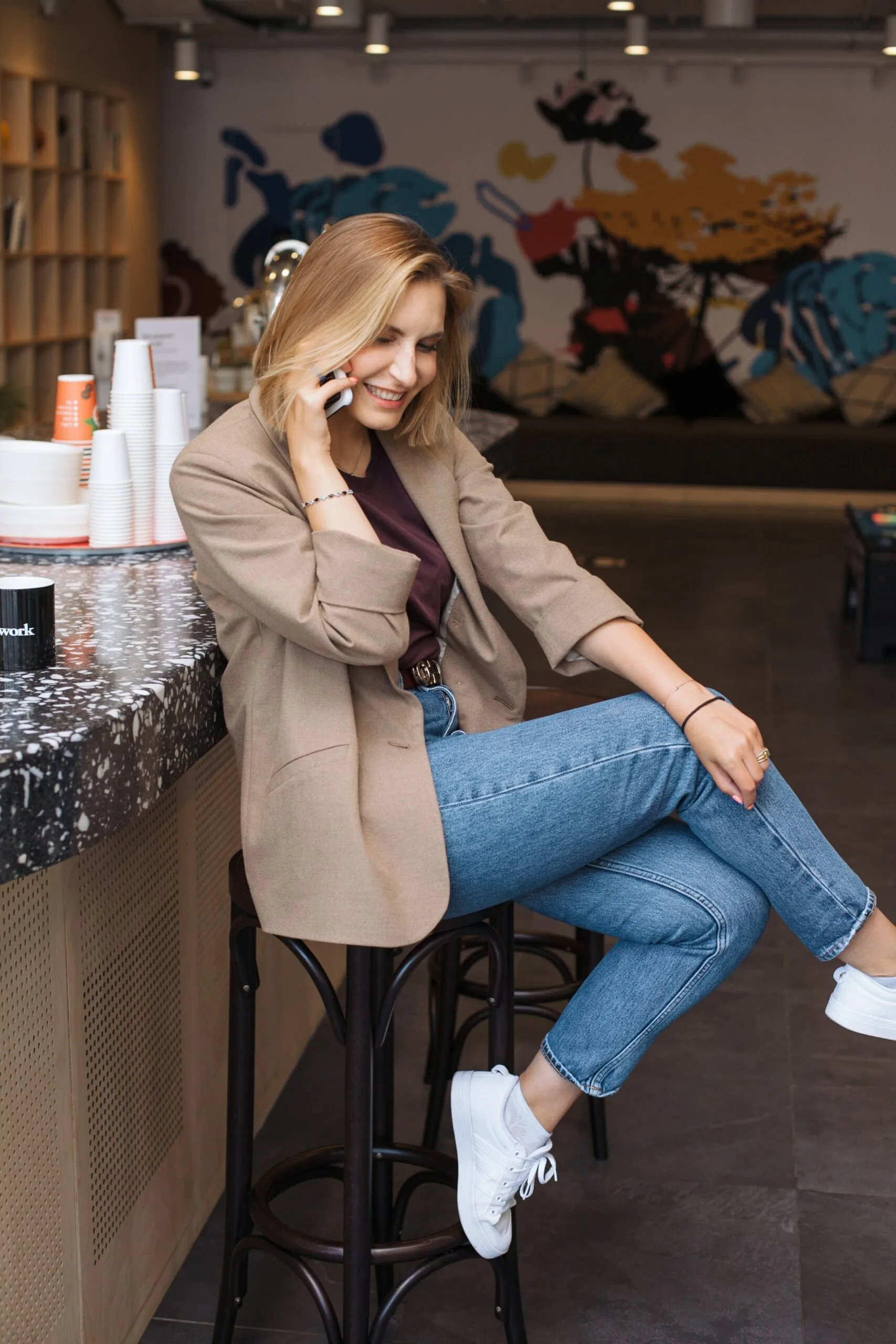 happy female sitting at a bar while talking on a phone
